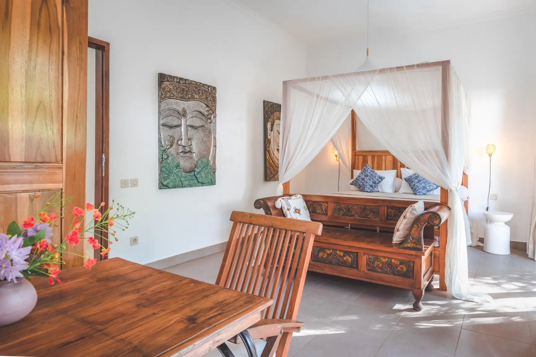 Garden bedroom view from desk, showing carved bench and Balinese Buddha art