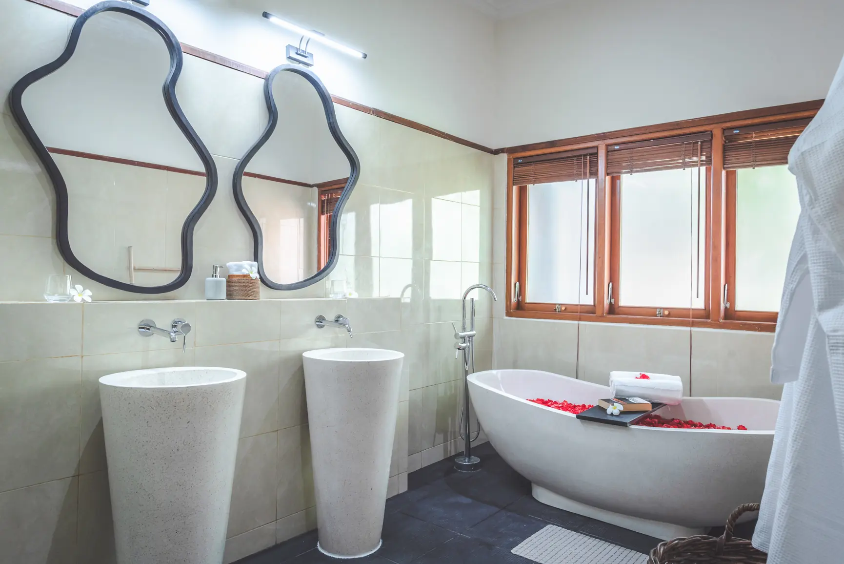 Master bathroom with twin pedestal sinks and freestanding bathtub