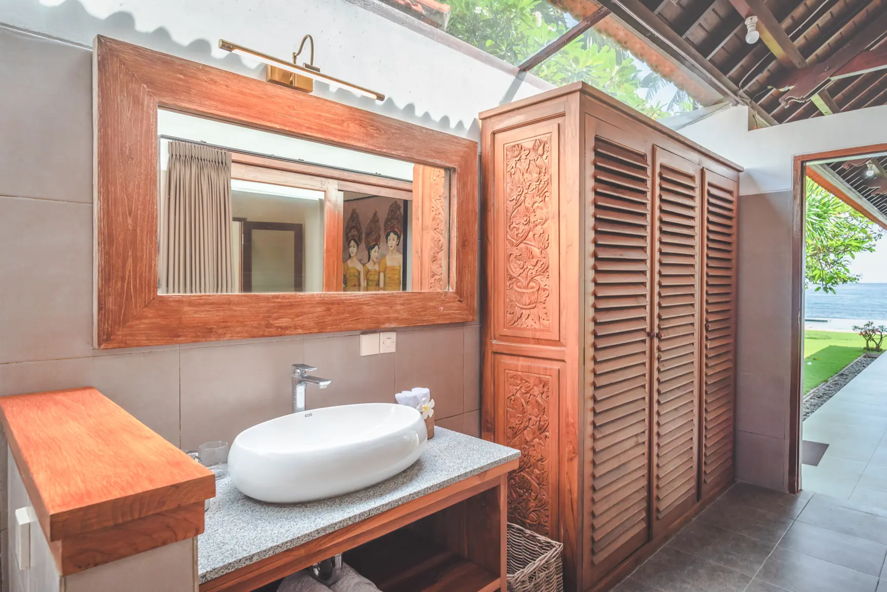 Ocean bedroom bathroom with sea view through frangipani trees