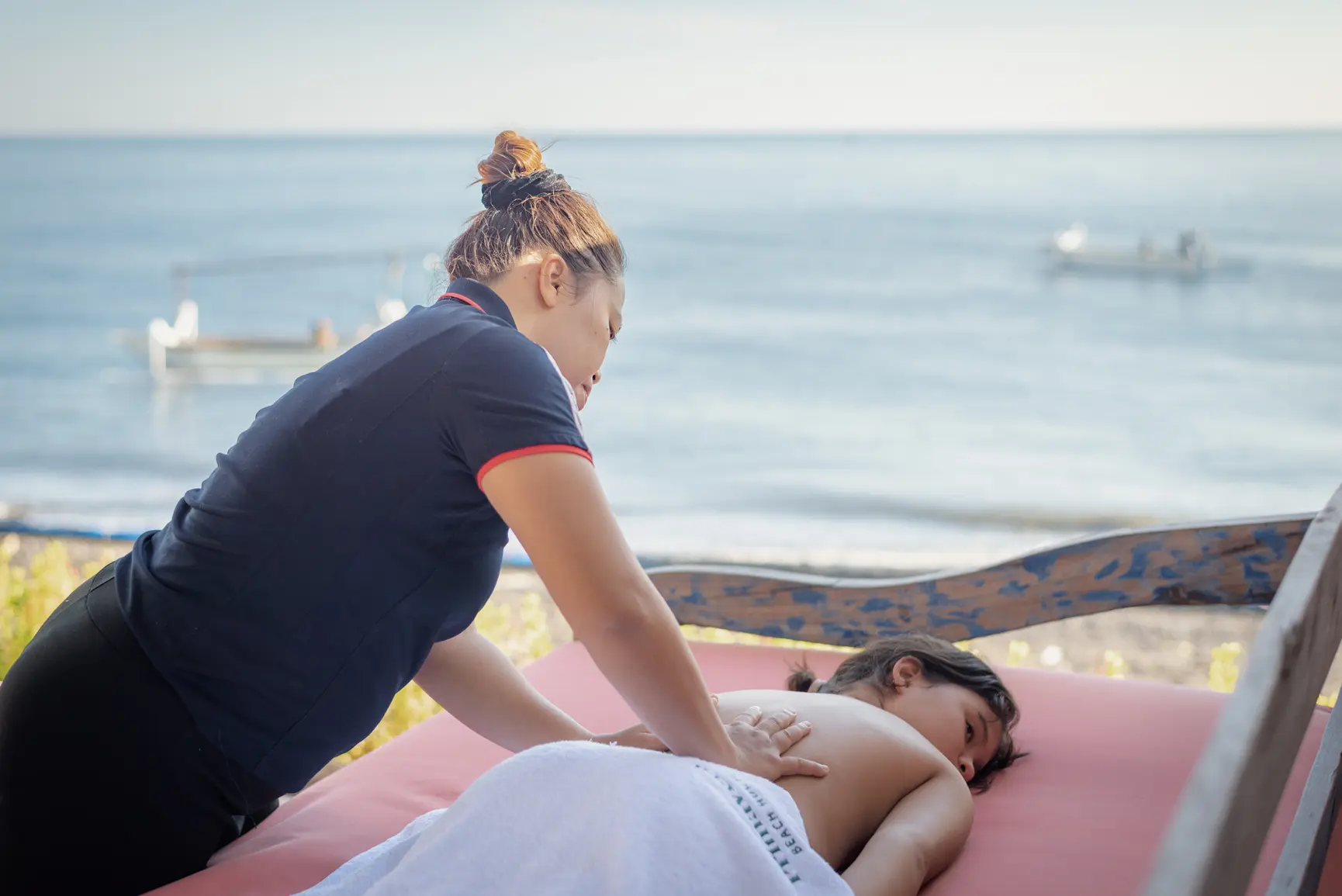 Massage table set up on the bale beside the pool at Primavera Beach House, with the sea behind.